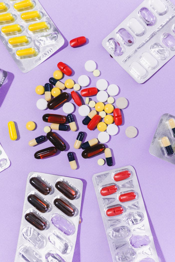 why-choose-us Close-up of various pills and capsules on a purple backdrop, showcasing pharmaceutical diversity.